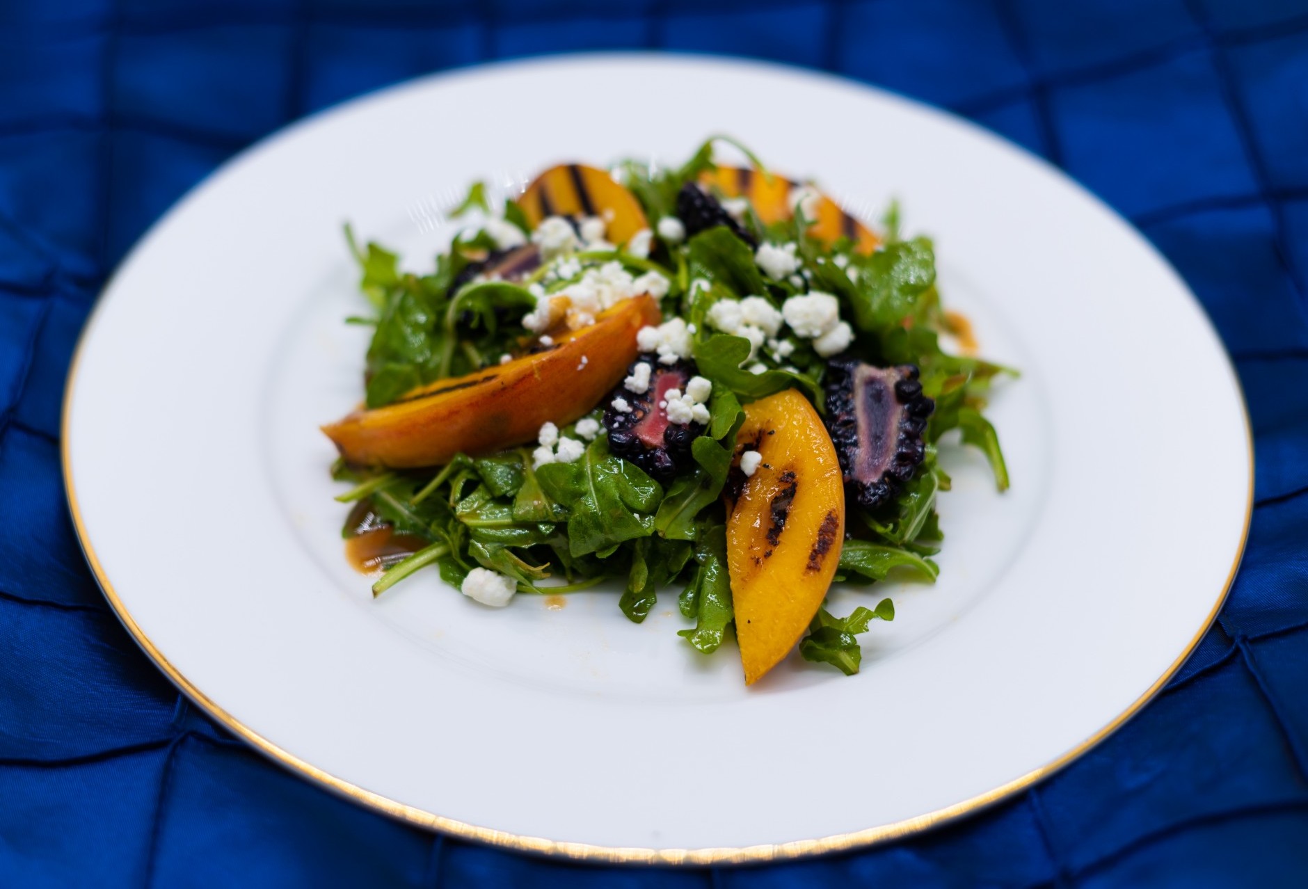 White plate with salad and grilled peaches