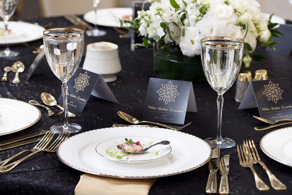 Photo of table with elegant place settings and flowers.
