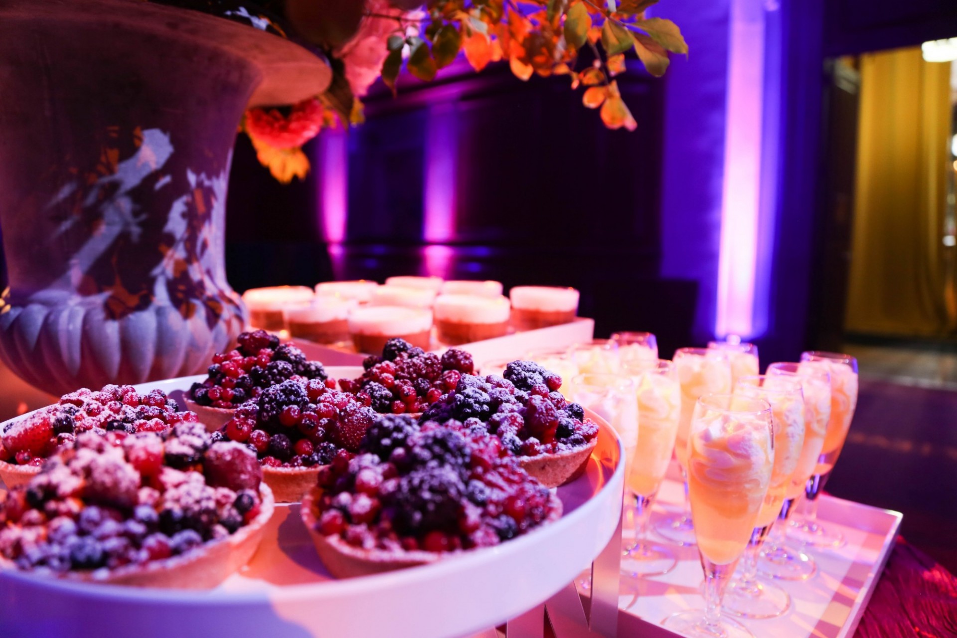 Berry tarts are set next to cocktails in champagne flutes