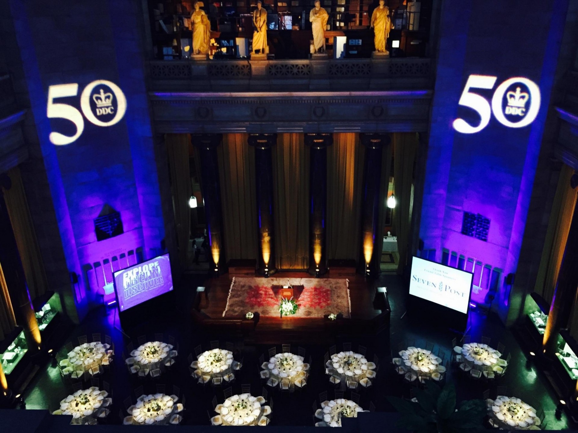 Special lighting effects create custom displays An aerial view of the Rotunda. The room is set with round tables and lights project a logo onto the walls.