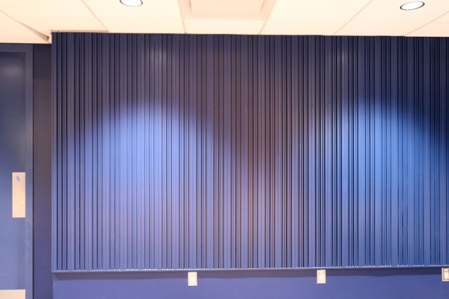 The wall opposite the stage features acoustic wood paneling