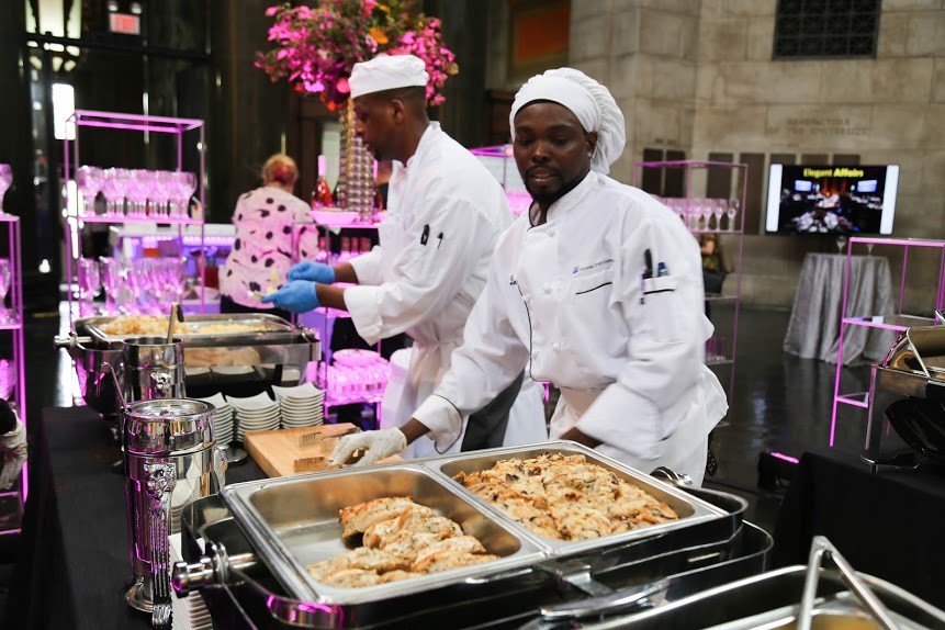 Chefs prepare food at an event in Low Library
