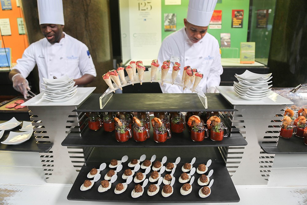 Two chefs serving delicious appetizers.