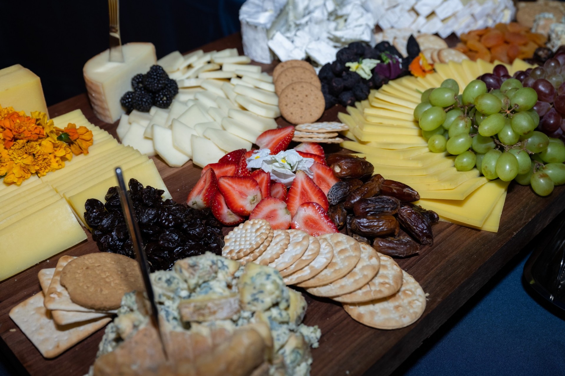 A charcuterie board with assorted cheese, fruit, and breads