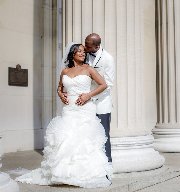 Focused on each other - a newly married couple embraces, looking content and joyful on the steps of Low Library.