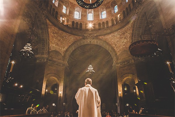 A clergyman stands at the altar