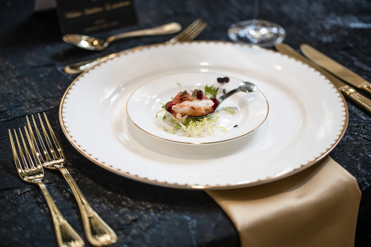 An amuse bouche featuring grapefruit poached lobster and pomegranate