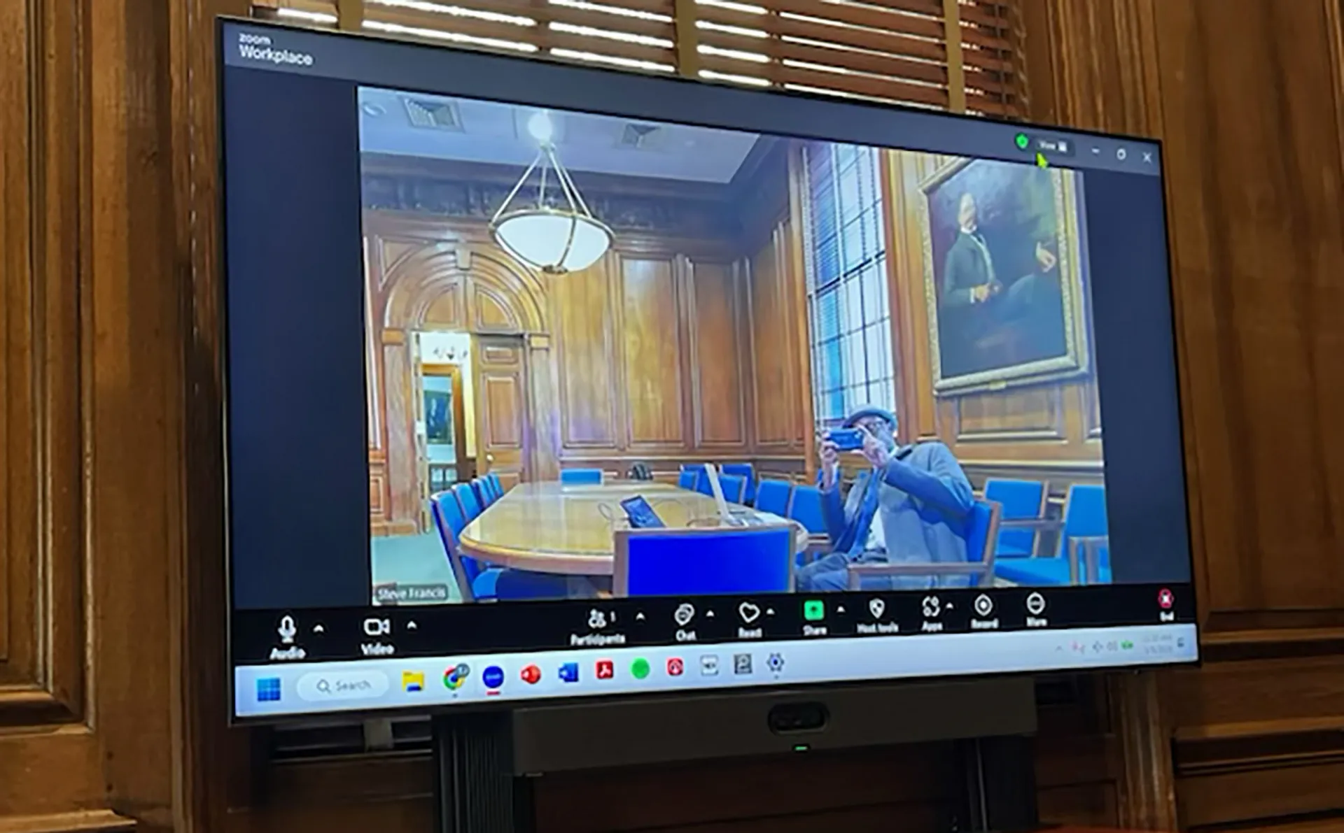 A screen shows the room participant on a Zoom call, demonstrating the AV capabilities