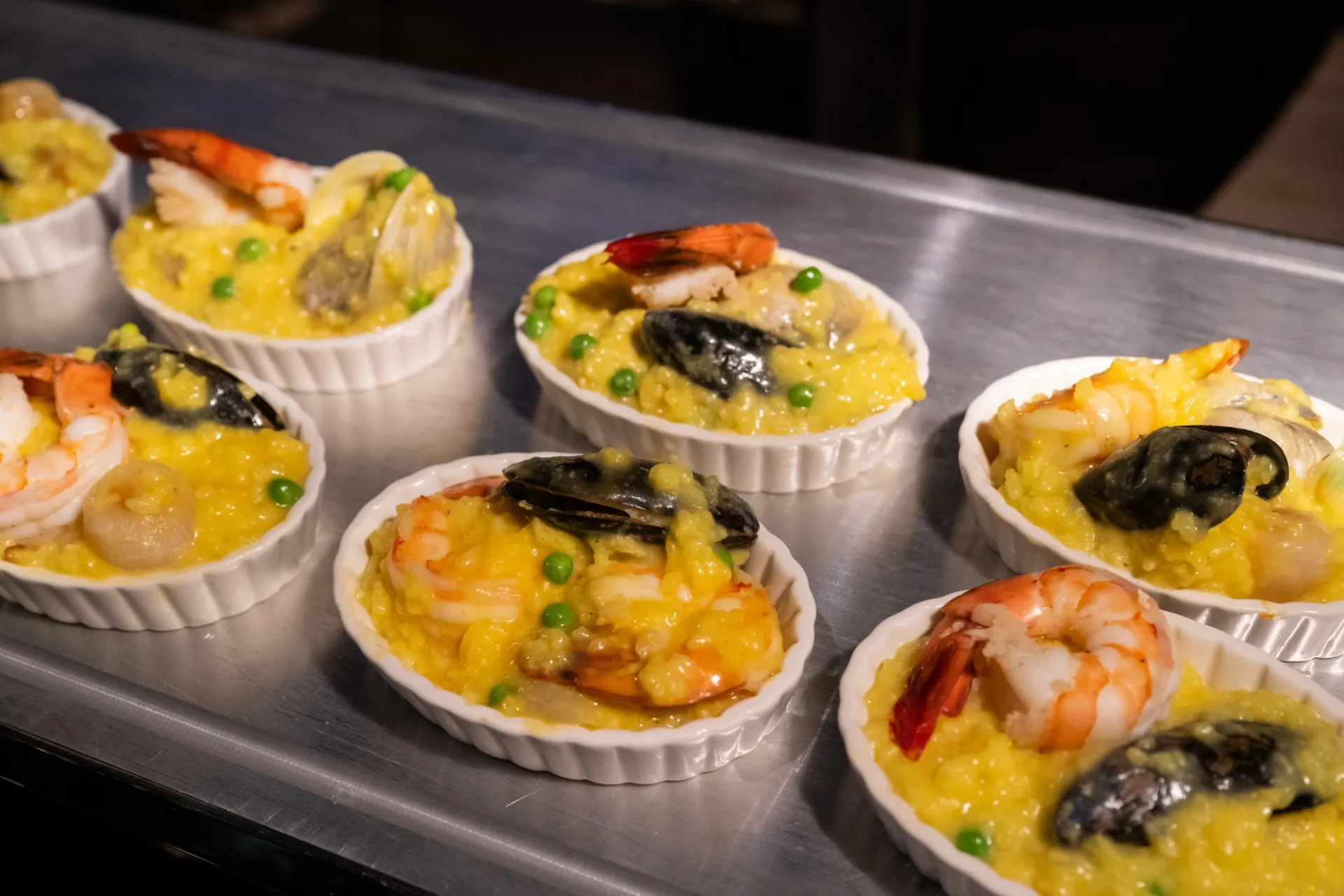 Ramekins of paella on a silver tray