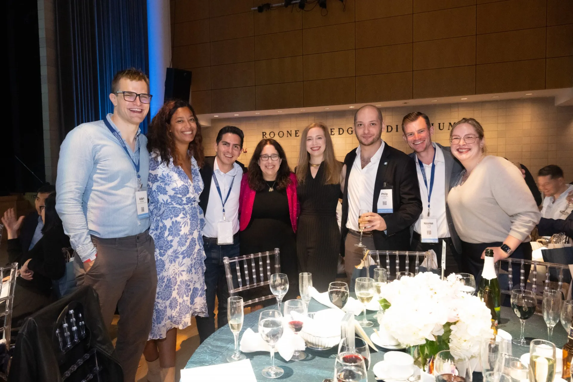A group of guests stands together near their table