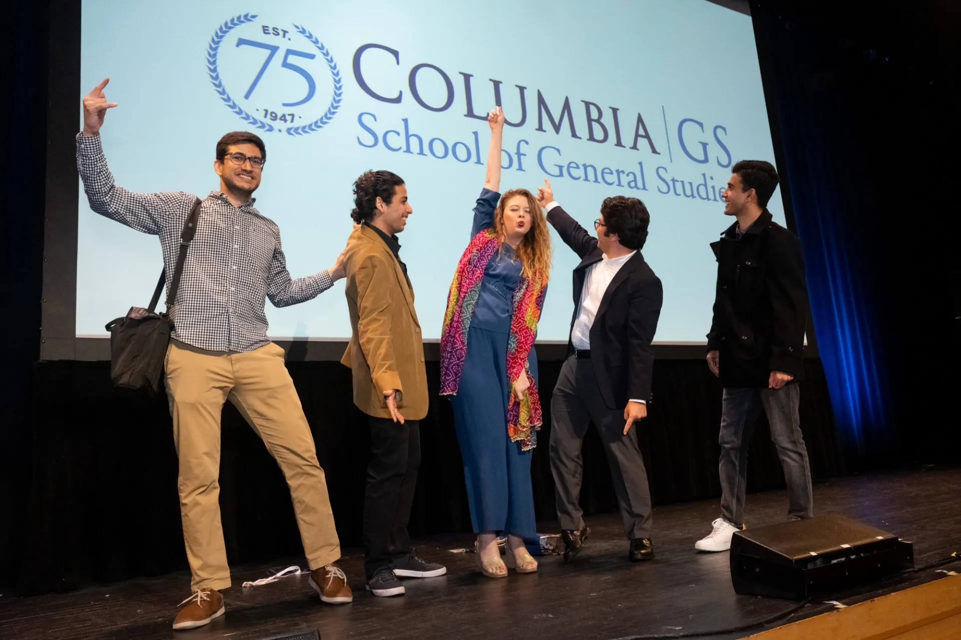 A group poses on stage