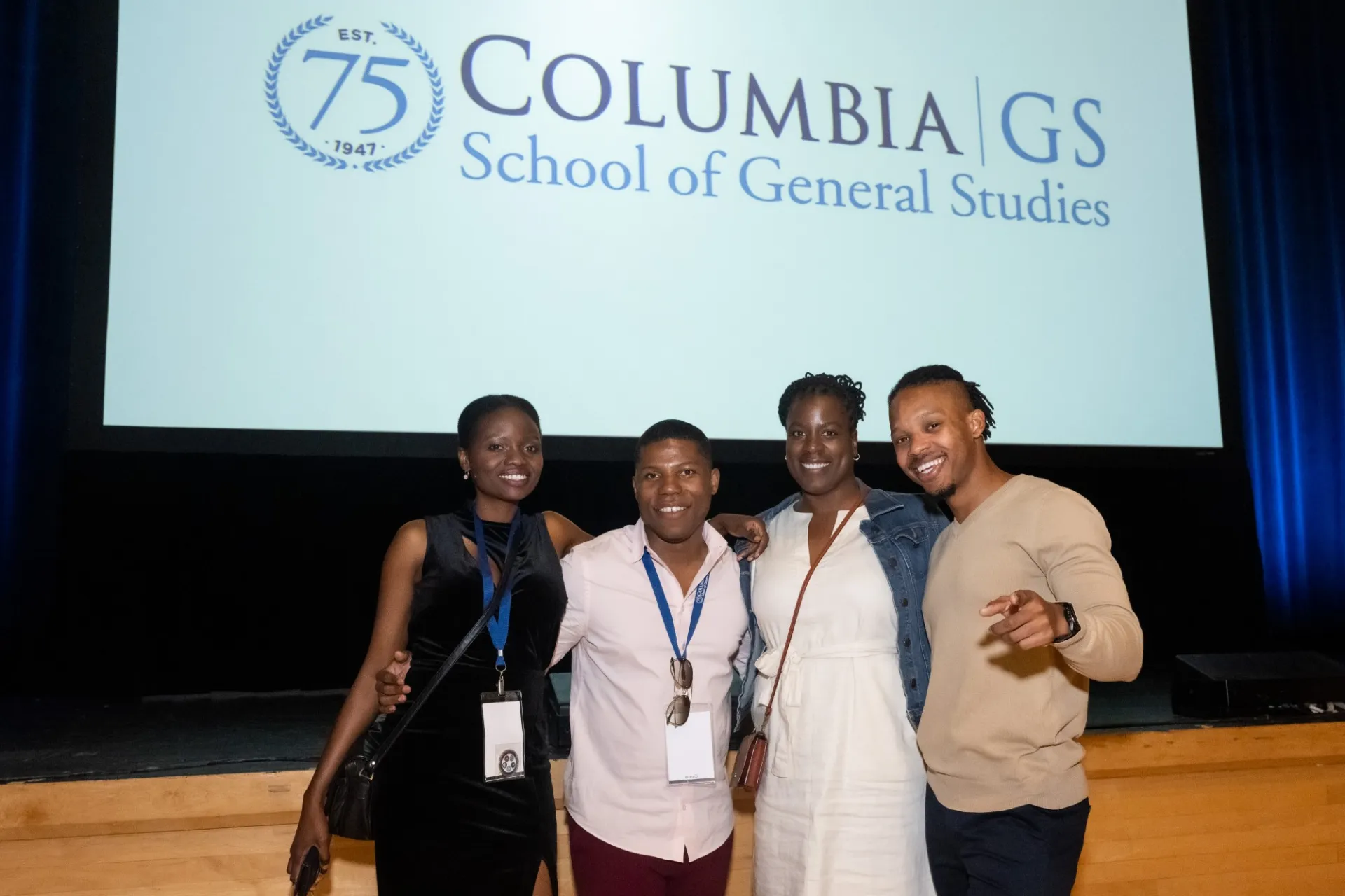 A group of guests poses together in front of the stage